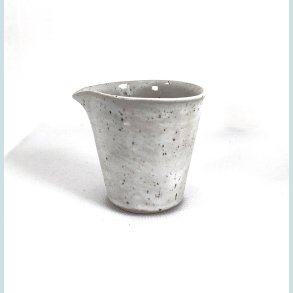 Lille m�lke/fl�dekande i sand med sorte nister