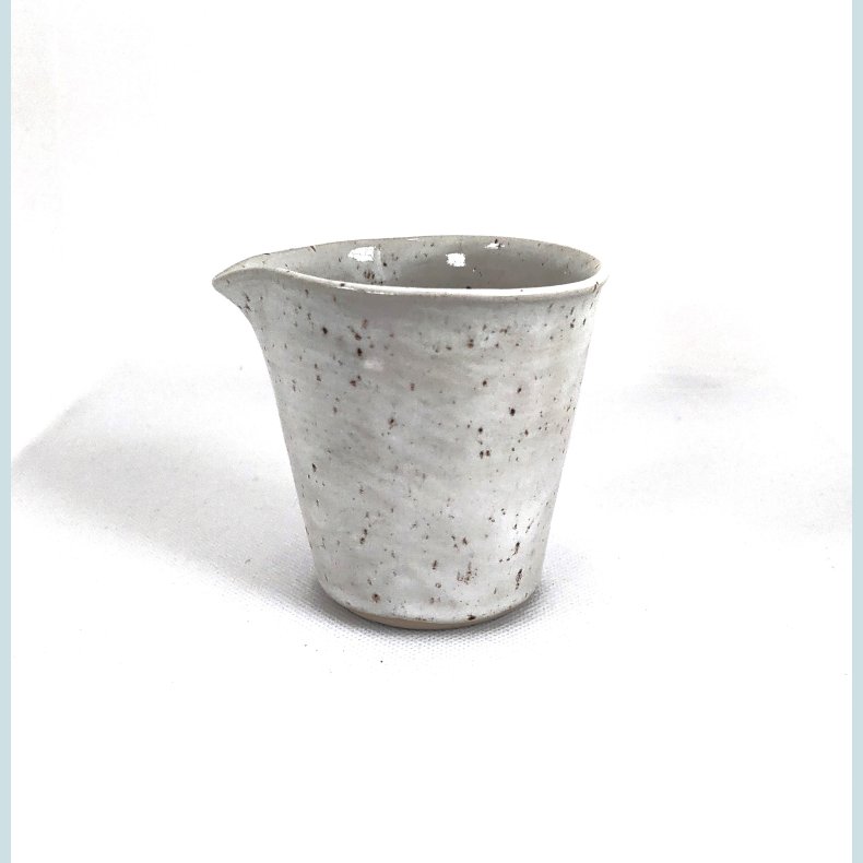 Lille m�lke/fl�dekande i sand med sorte nister