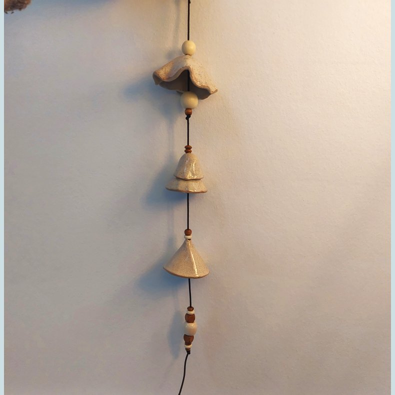 Klokke i l�dersnor i cremeglasur med nister og tr�perler